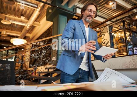 Gladsome gentleman using tablet for his office job Stock Photo