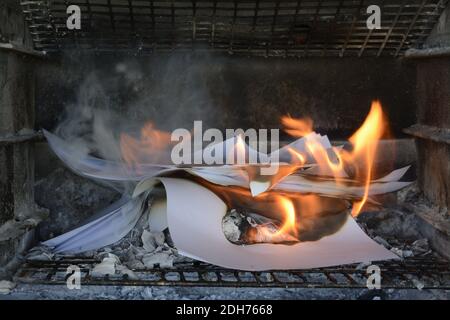 Burning paper documents. Flames and scorched paper. Good example of destroying evidence by burning it. Ashes left behind. Stock Photo