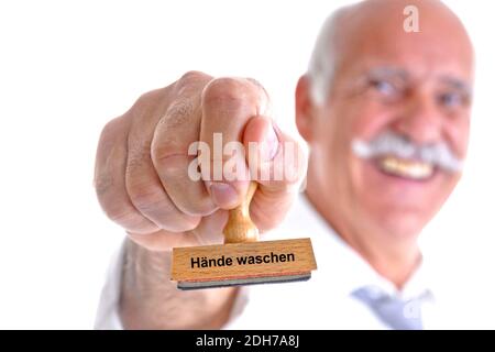 65, 70, Jahre, Mann hält Stempel in der Hand, Aufschrift: Hände waschen, Virus, Bakterien, Corona, Coronavirus, Covid-19,
