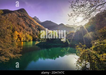 Isola Santa medieval village, lake and Alpi Apuane mountains in autumn foliage. Garfagnana, Tuscany, Italy Europe. Stock Photo