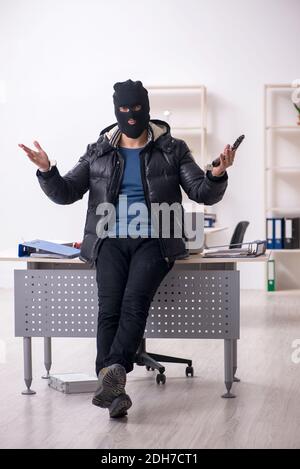 Young male burglar in the office Stock Photo