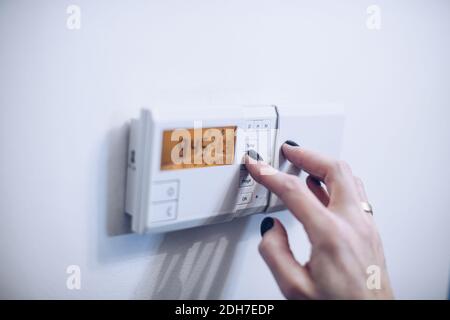 Regulating temperature on modern home heating control panel Stock Photo