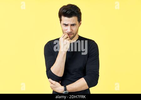Serious houghtful man have a doubt over yellow background Stock Photo