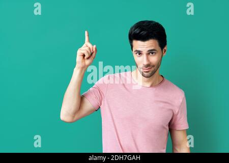 Handsome thoughtful man pointing his finger up Stock Photo