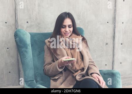 Woman using smartphone in lobby of modern office building Stock Photo