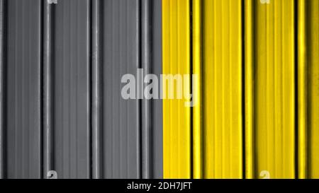 Bright metal gray and yellow painted shutter or roller blind. Stock Photo