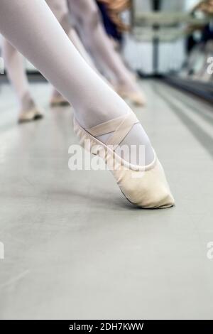 Young ballerinas dancing at dance studio, close up of ballet shoes. Stock Photo