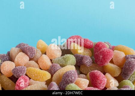 A colorful variety of candies piled up with blue background with space to insert a text on top. Stock Photo