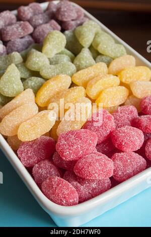 Close-up of red sugar sweeties with colorful candies out of focus background. High in sugar foods. Stock Photo