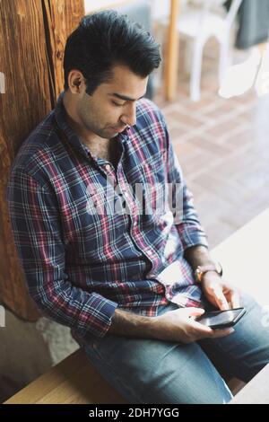 Man using smart phone in restaurant Stock Photo
