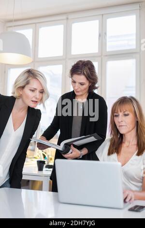 Businesswomen working on laptop in office Stock Photo