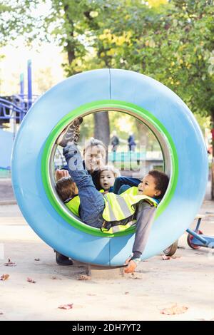 Teacher and children playing in tube Stock Photo