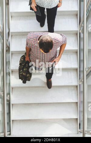 High angle view of businesspeople moving down steps in office Stock Photo
