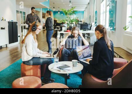 Business people using laptops in creative office Stock Photo