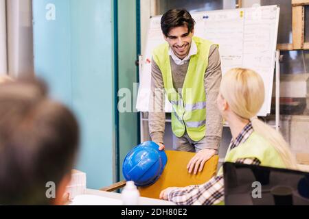 Manual workers conversing in factory Stock Photo