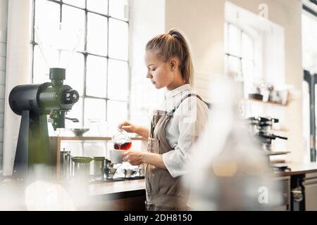 Barista making coffee at cafe counter Stock Photo