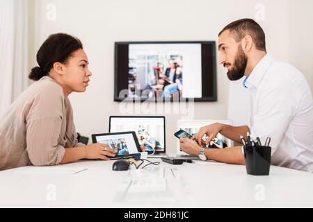 Side view of business people using technologies at table Stock Photo