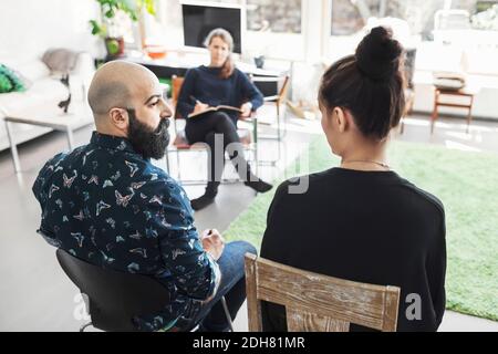 Couple talking to woman taking notes Stock Photo