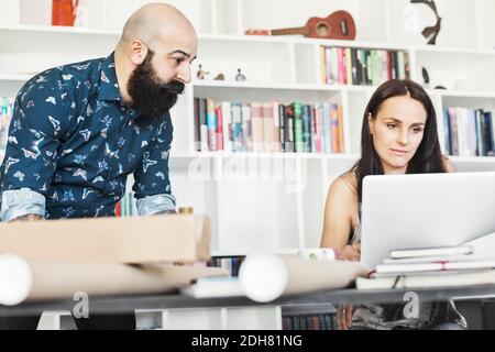 Male and female architects using laptop at home office Stock Photo