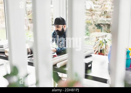 Male architect working at table in home office Stock Photo