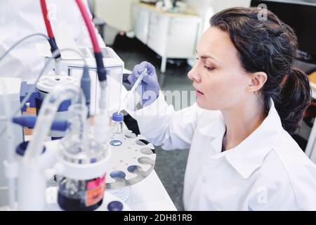 Female scientist using pipette in laboratory Stock Photo