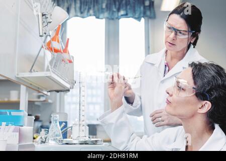Female scientists analyzing chemical in laboratory Stock Photo