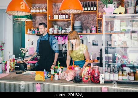 Man and woman working at cafe counter Stock Photo