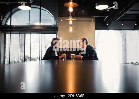 Senior couple talking while having coffee at cafeteria Stock Photo