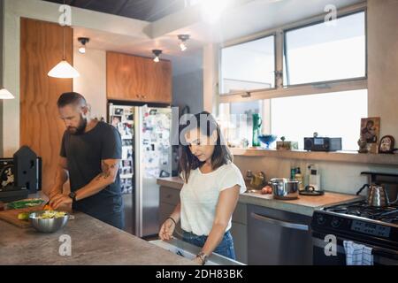 Couple preparing food together in kitchen Stock Photo
