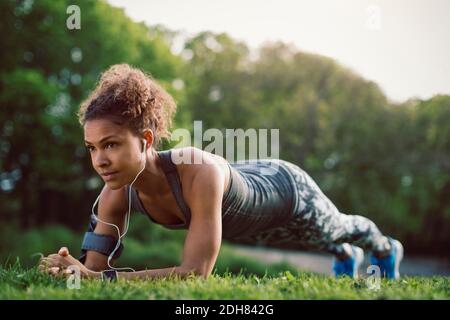 Sporty woman doing plank exercise at park Stock Photo