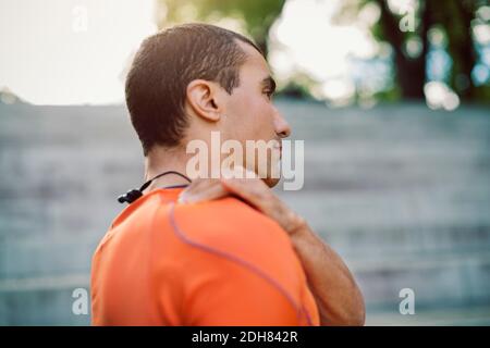 Man touching shoulder while standing on steps Stock Photo