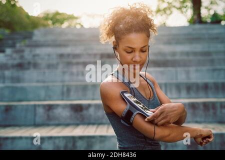 Woman using smart phone armband while exercising Stock Photo