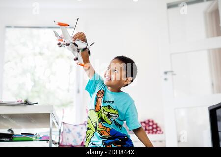 Happy boy playing with model airplane at home Stock Photo