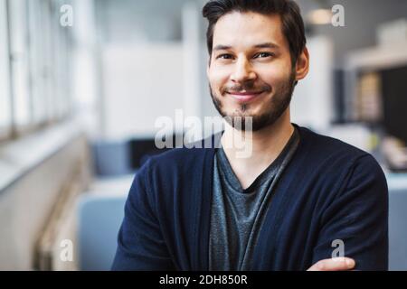 Portrait of confident businessman smiling in office Stock Photo