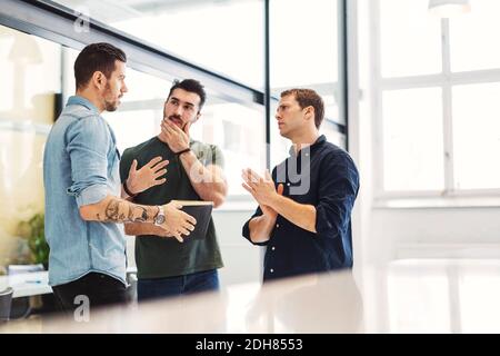Businessman having discussion with male colleagues in office Stock Photo