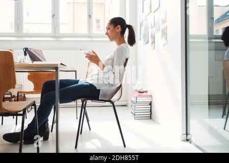 Young businesswoman having coffee at desk in office Stock Photo