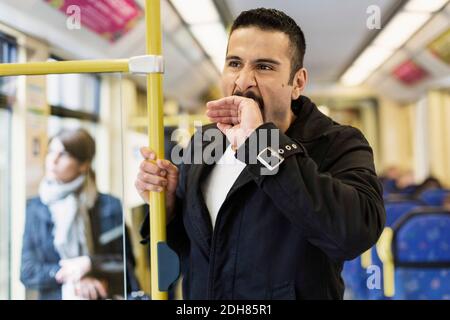 Bored young man yawning in tram Stock Photo