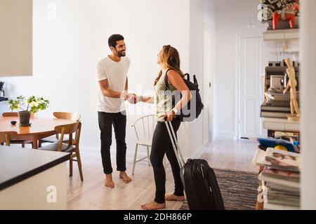 Happy man shaking hand with woman going for vacation Stock Photo