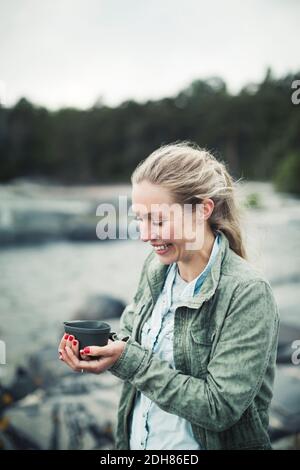 Happy wonderlust woman holding coffee mug outdoors Stock Photo