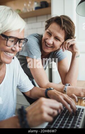 Happy product designers discussing over laptop at home Stock Photo