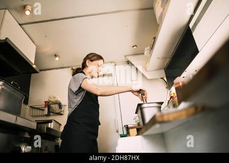 Low angle view of woman preparing food in truck Stock Photo