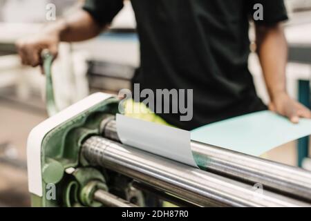 Midsection of young student using machine in workshop Stock Photo
