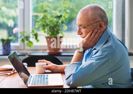 Senior man using laptop at home Stock Photo