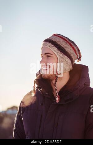 Happy young man looking away against clear sky during winter Stock Photo