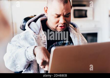 Disabled man using laptop in recording studio Stock Photo