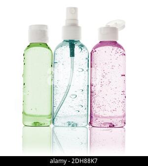 three toiletry bottles with water droplets on white background Stock Photo
