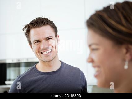 Portrait of smiling mid adult man with woman in foreground Stock Photo