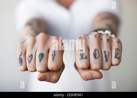 Mid section of a man showing love tattoos on his fists Stock Photo