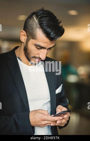 Young businessman using mobile phone in creative office Stock Photo