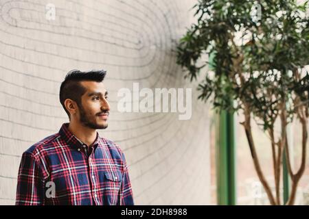 Thoughtful businessman looking away in creative office Stock Photo